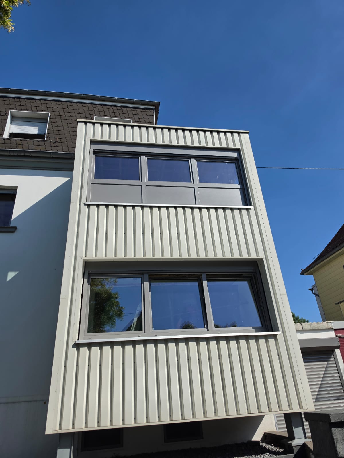 Moderne Fensterelemente in RAL 7016 an einer verputzten Fassade