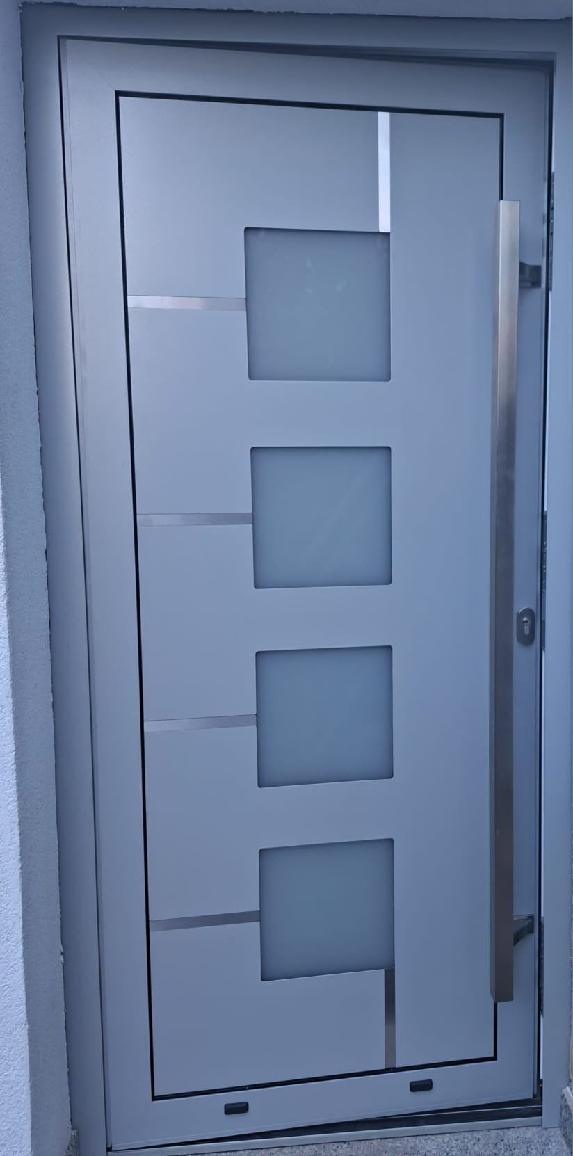Moderne graue Haustür mit satinierten Glasfeldern und Edelstahl-Griff